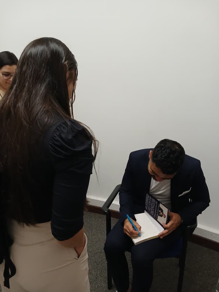 Felipe López firmando el libro Abundantemente a una lectora